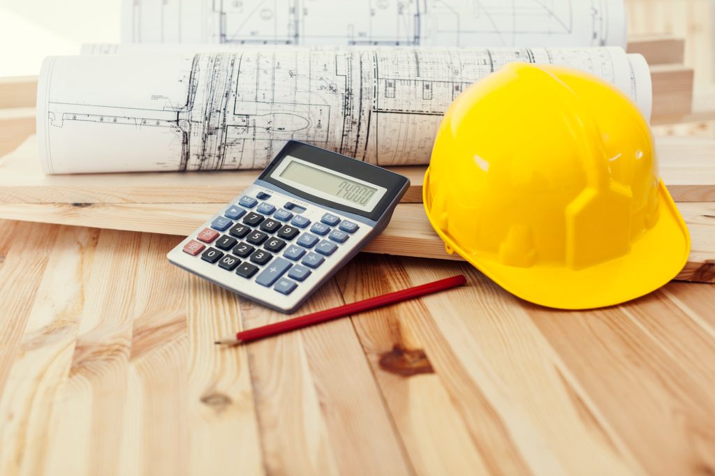 Construction plans and safety helmet representing commercial construction loan financing